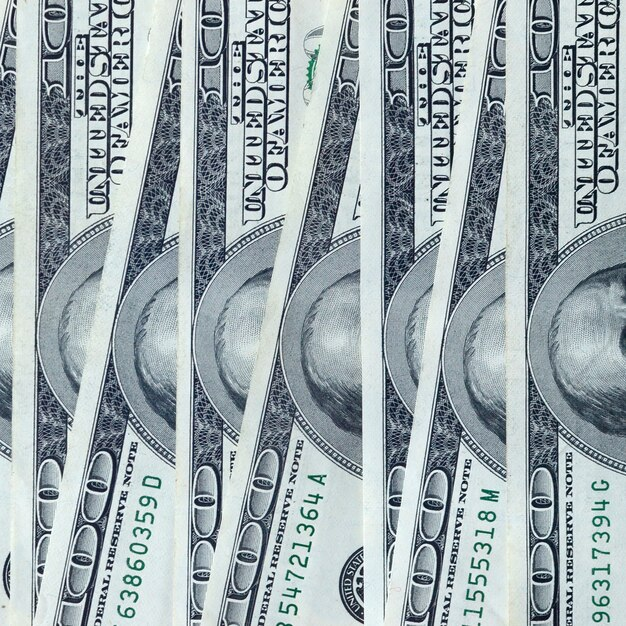Abstract backdrop with many hundred dollar bills close up